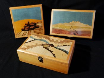 Boites à secret ornées d'une marqueterie de paysage imaginaire. La structure apparente est en merisier et les placages intérieurs sont en loupe d'amboine et ronce de noyer. Atelier de la baleine. 2026.