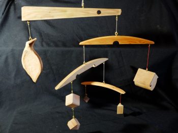 Série des "mobiles ésotériques". Mobiles de décoration dont le vent fait se mouvoir des éléments géométriques et abstraits, et révèle les tensions physiques entre eux. Différentes essences utilisées: olivier, if, cyprès, noyer, châtaignier, chêne... Atelier de la baleine. 2026