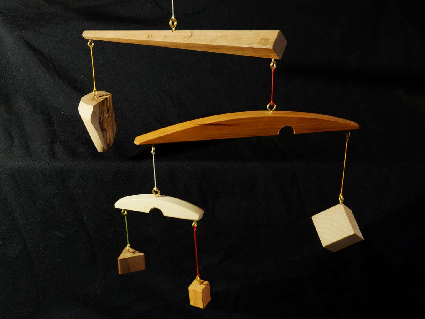 Série des "mobiles ésotériques". Mobiles de décoration dont le vent fait se mouvoir des éléments géométriques et abstraits, et révèle les tensions physiques entre eux. Différentes essences utilisées: olivier, if, cyprès, noyer, châtaignier, chêne... Atelier de la baleine. 2026
