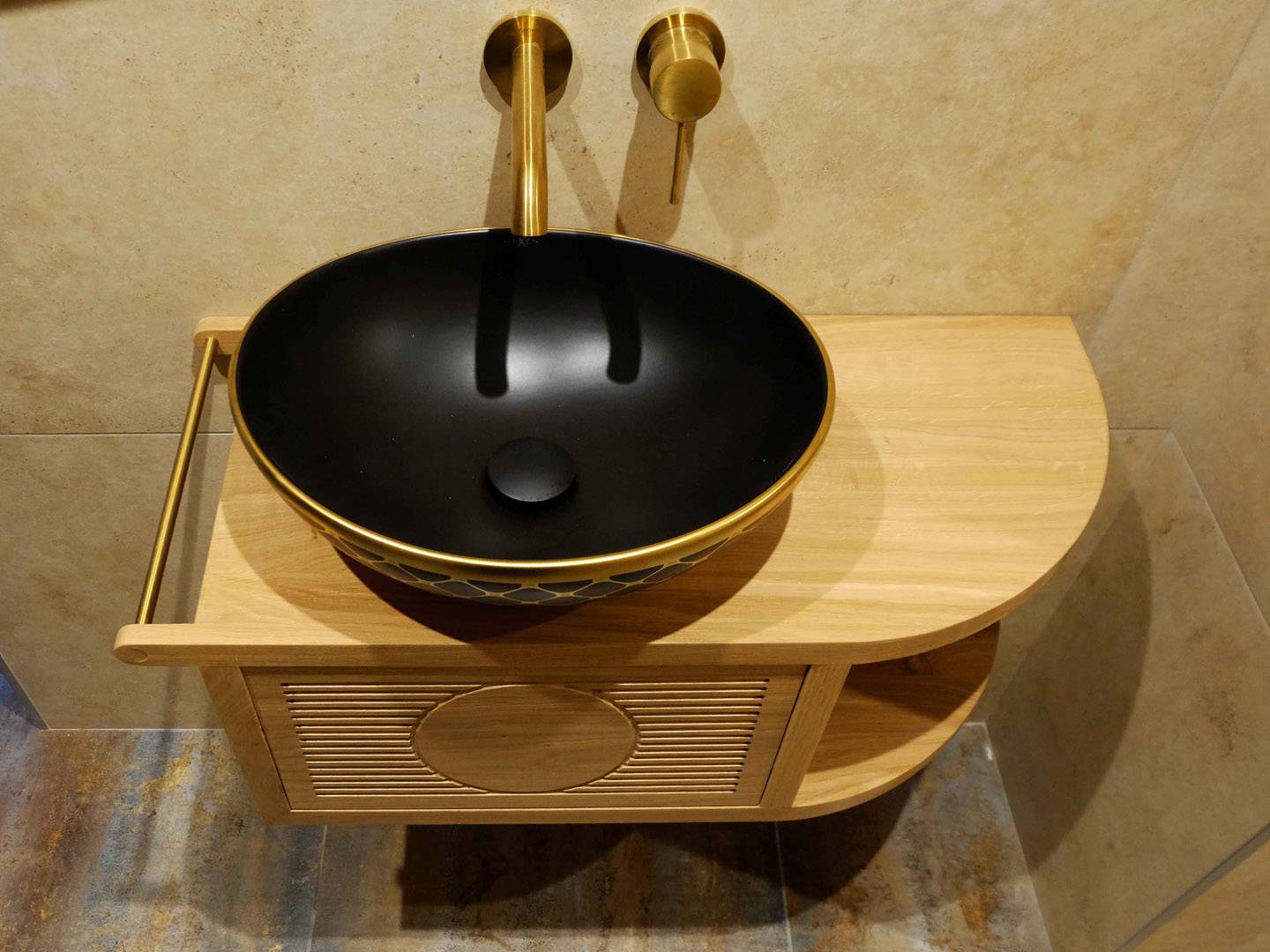 Petite console suspendue au mur accueillant une vasque. La façade du tiroir est ornée d'un dessin géométrique fait par un défonçage de petites gorges. Essence de bois en chêne et finition vernie. Atelier de la baleine. 2025.