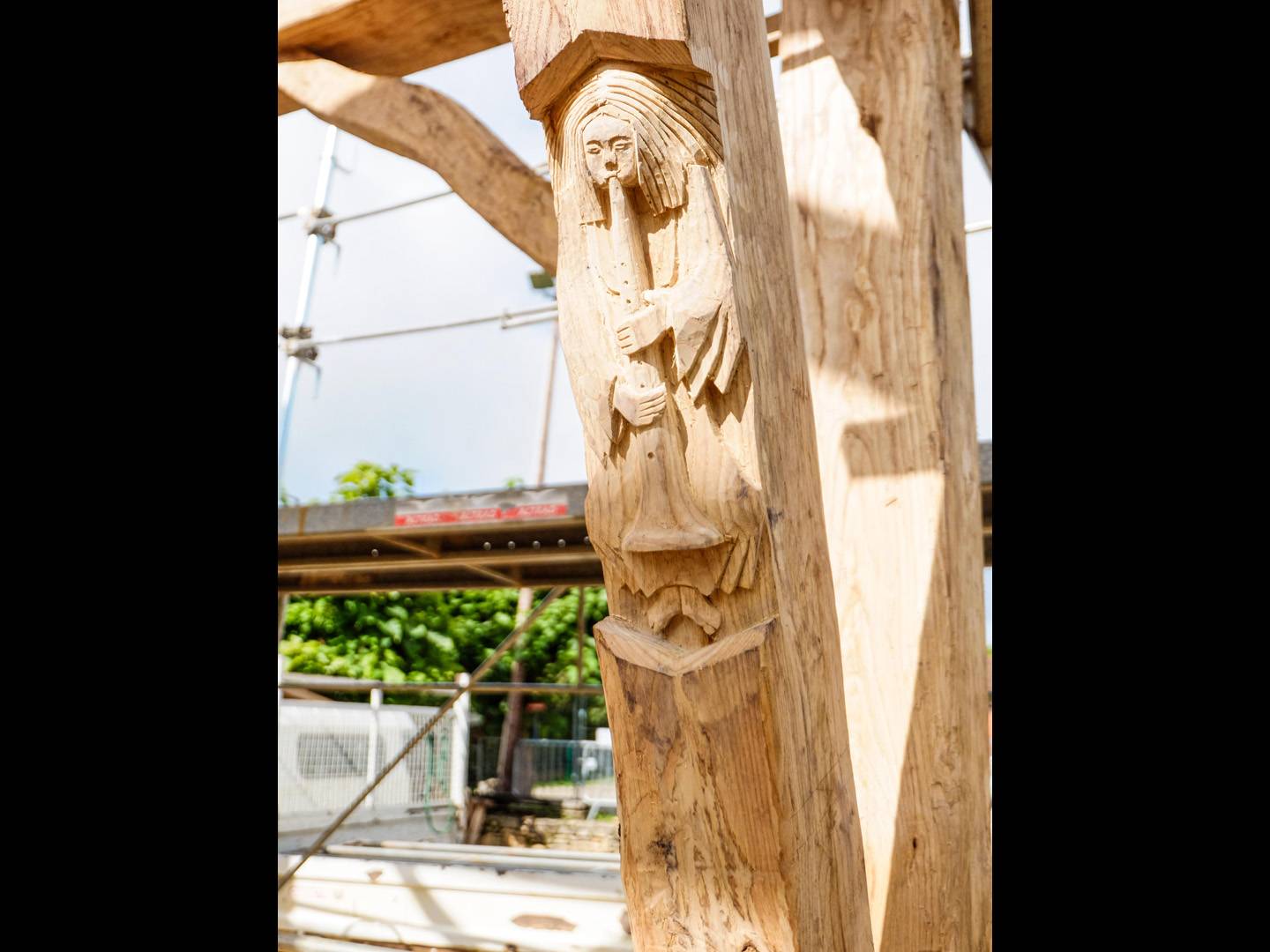 Sculpture ornementale : flutiste. Cette sculpture a été réalisée dans la jambe de force d'une charpente traditionnelle faite en châtaigner. Atelier de la baleine. 2021