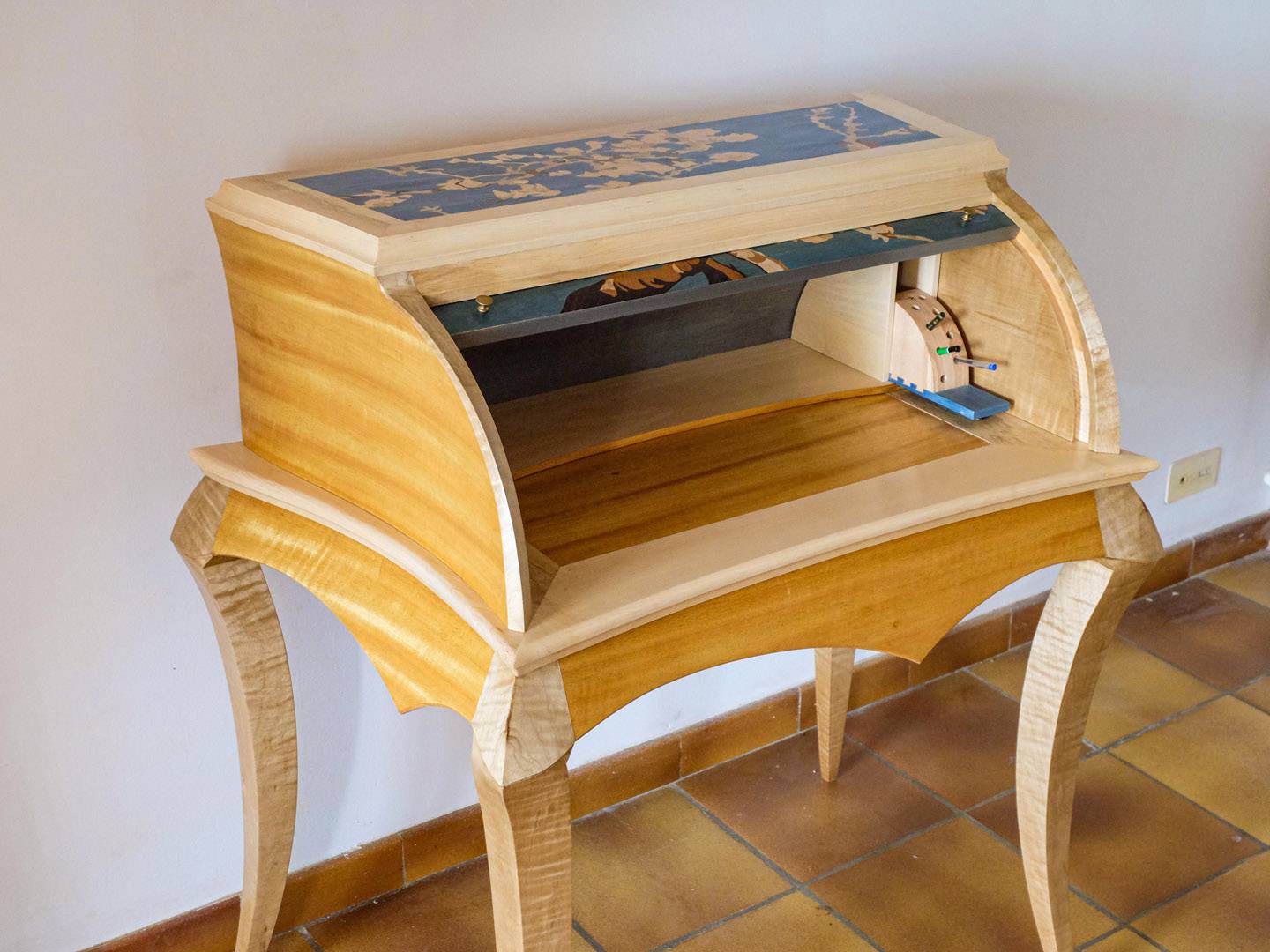 Bureau cylindre contemporain. Ce meuble aux pieds galbés est entièrement plaqué. Le cylindre et le plateau portent une marqueterie dont l'inspiration vient des "amandiers en fleur" de Van Gogh. Meuble d'étude. Atelier de la baleine. 2020