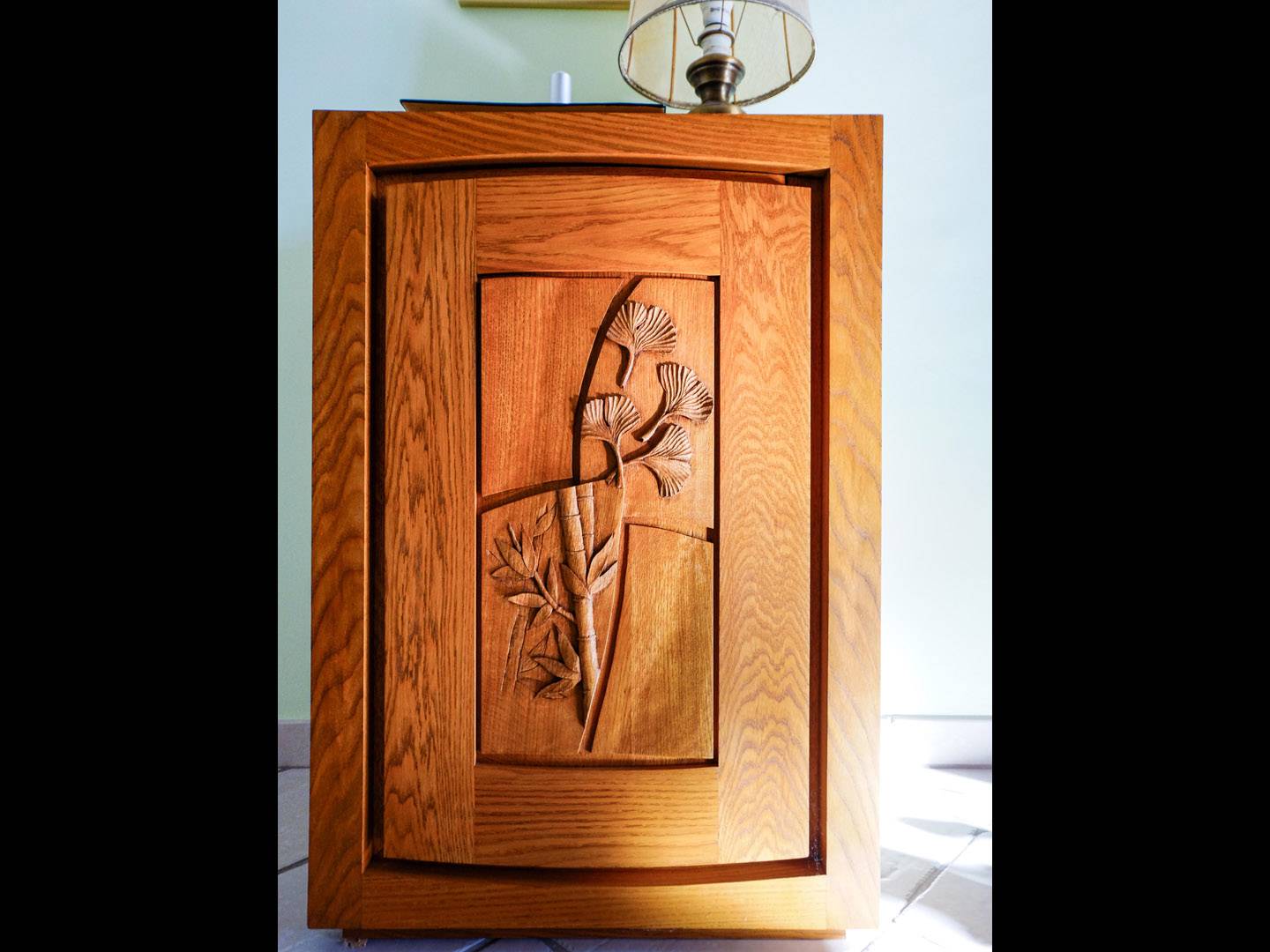 Confiturier contemporain. Ce meuble comporte un tiroir intérieur, un secret, et une porte sculptée d'un bas relief : bambou et feuille de guincobiloba. Réalisation faite en chêne teinté et ciré. Meuble d'étude. Atelier de la baleine. 2019