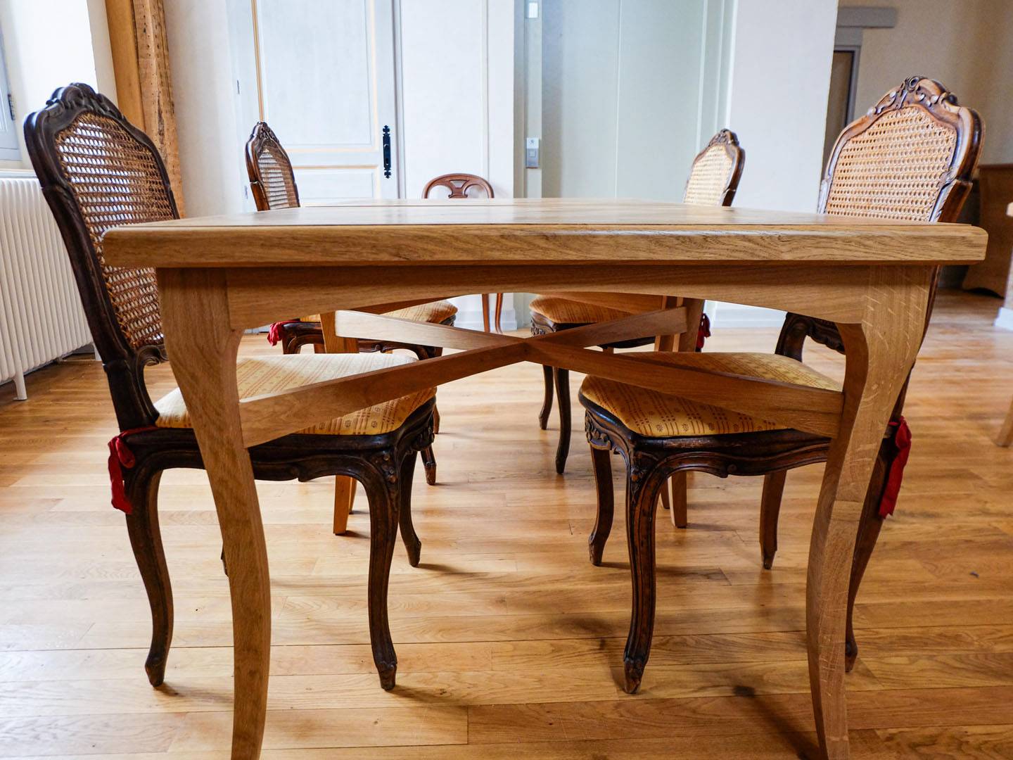 Tables de salle à manger. Ces tables ont été fabriquées en chêne, avec des pieds galbés traditionnels et deux traverses croisées. Les plateaux des tables sont faits d'un parquet Versailles restauré. Atelier de la baleine. 2023